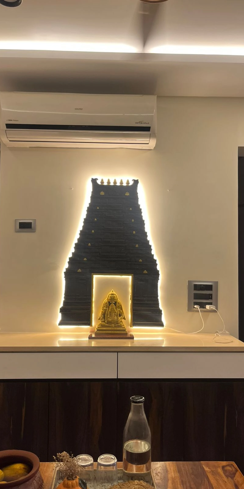 Rawdius Gopuram Customer Installation Backlit black gopuram wall decor with a gold Ganesha statue mounted above a counter