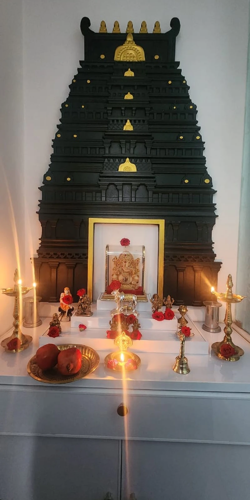 Rawdius Gopuram Customer Installation Black and gold gopuram wall installation with a small Ganesha shrine lit by brass lamps