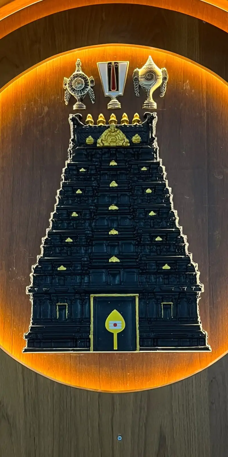 Rawdius Gopuram Customer Installation Black gopuram wall decor with gold accents and sacred symbols lit inside a circular backlight frame