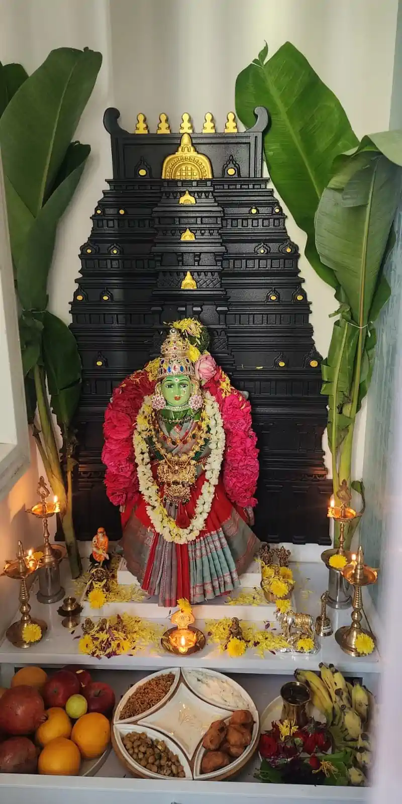 Rawdius Gopuram Customer Installation Black gopuram wall piece framing a decorated Goddess idol during a pooja setup