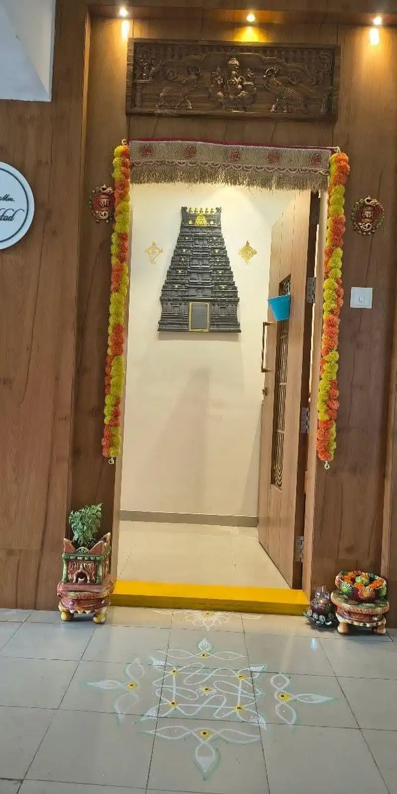Rawdius Gopuram Customer Installation Dark grey gopuram wall decor visible through a garland decorated doorway in a home entrance