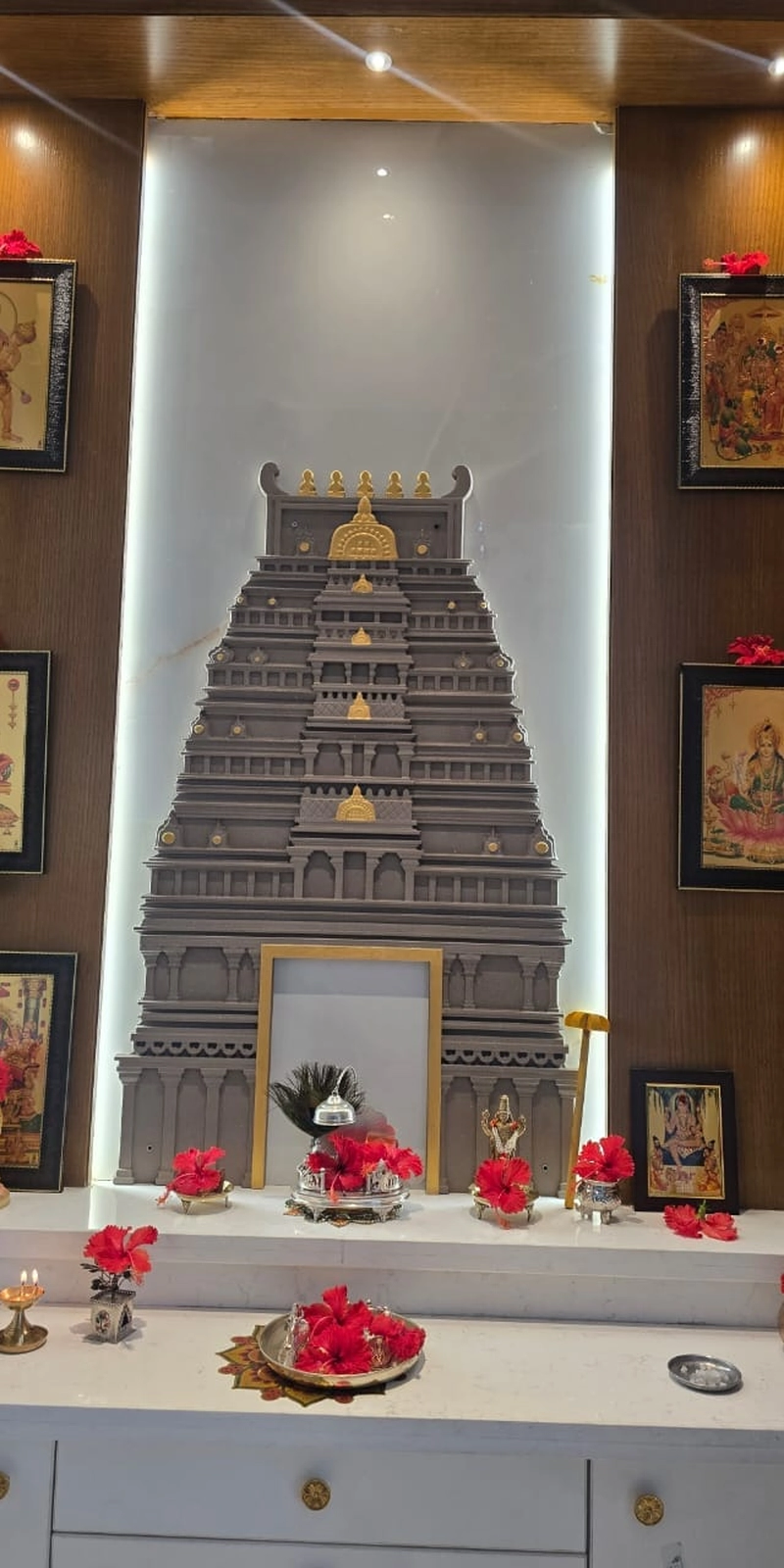 Rawdius Gopuram Customer Installation Grey and gold gopuram backdrop installed on a lit white glass panel in a pooja room