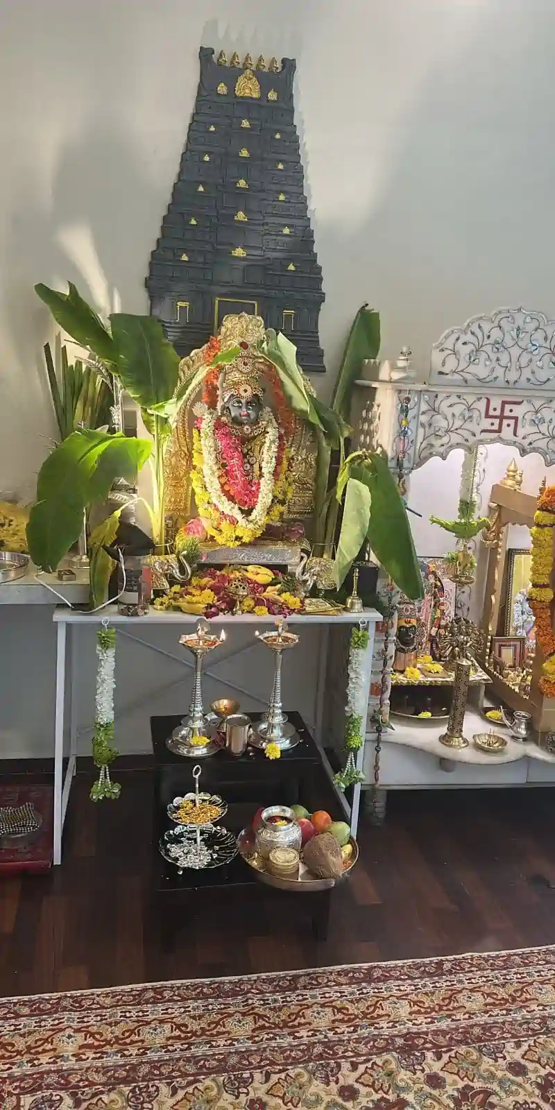 Rawdius Gopuram Customer Installation Grey temple gopuram backdrop behind a decorated idol and pooja altar setup