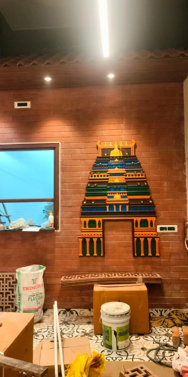 Rawdius Gopuram Customer Installation Multicolor gopuram wall decor with gold accents mounted on a exposed brick wall