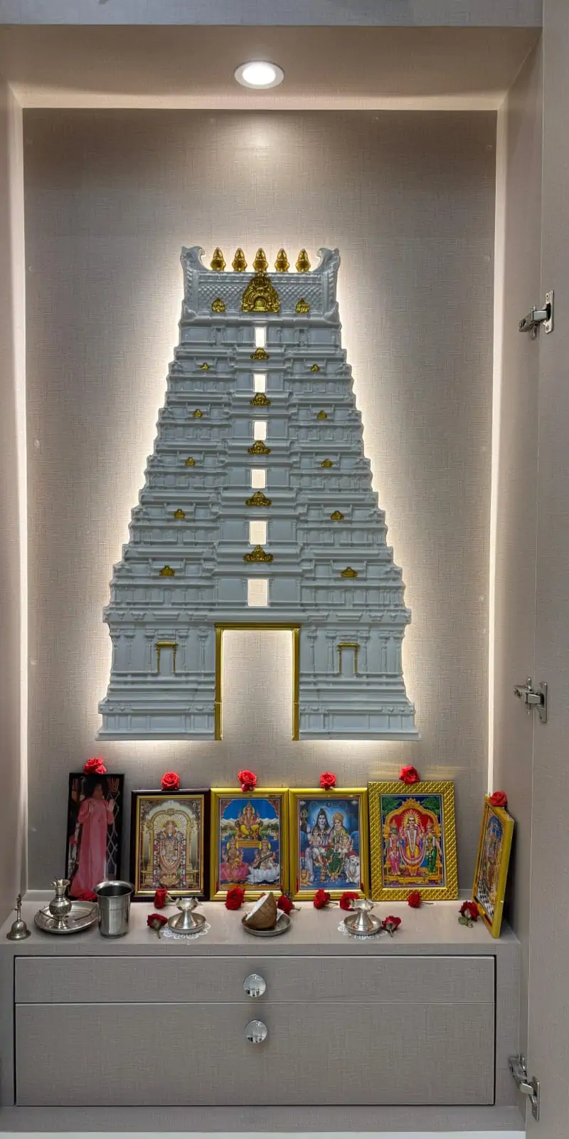 Rawdius Gopuram Customer Installation White backlit gopuram wall installation with gold highlights above framed deity pictures