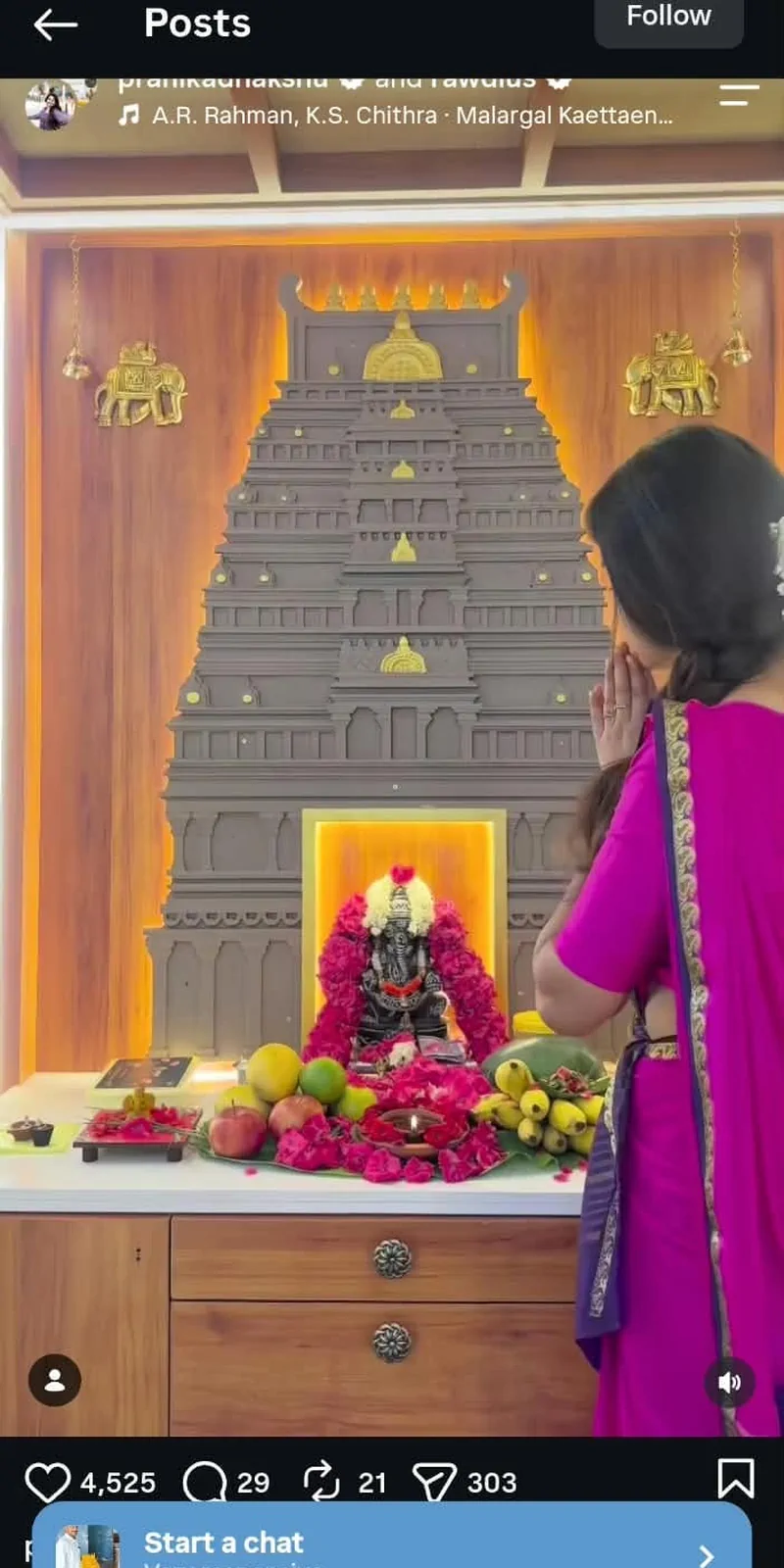 Rawdius Gopuram Customer Installation Woman offering prayers in front of a backlit wooden gopuram wall installation