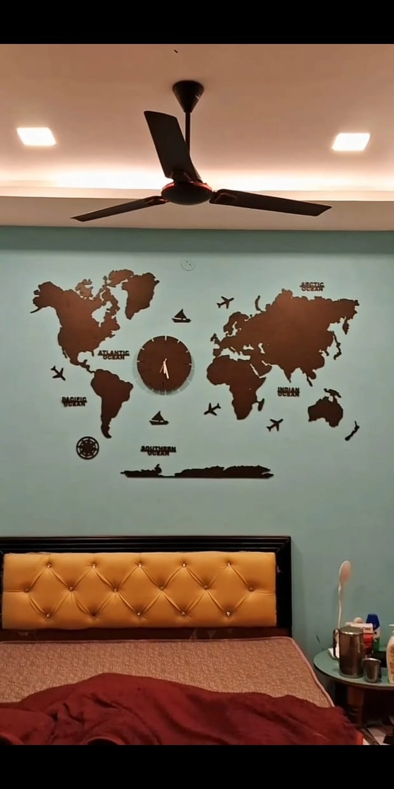 Rawdius Mirror Customer Installation Dark wooden world map with clock mounted on a light blue bedroom wall